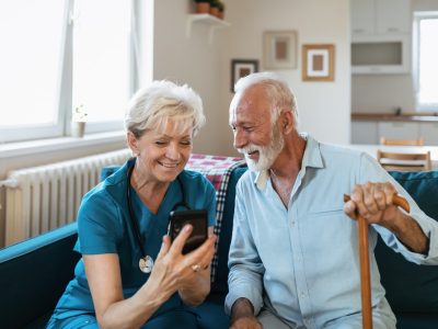 nurse ander gentleman looking at phone screen in home care setting
